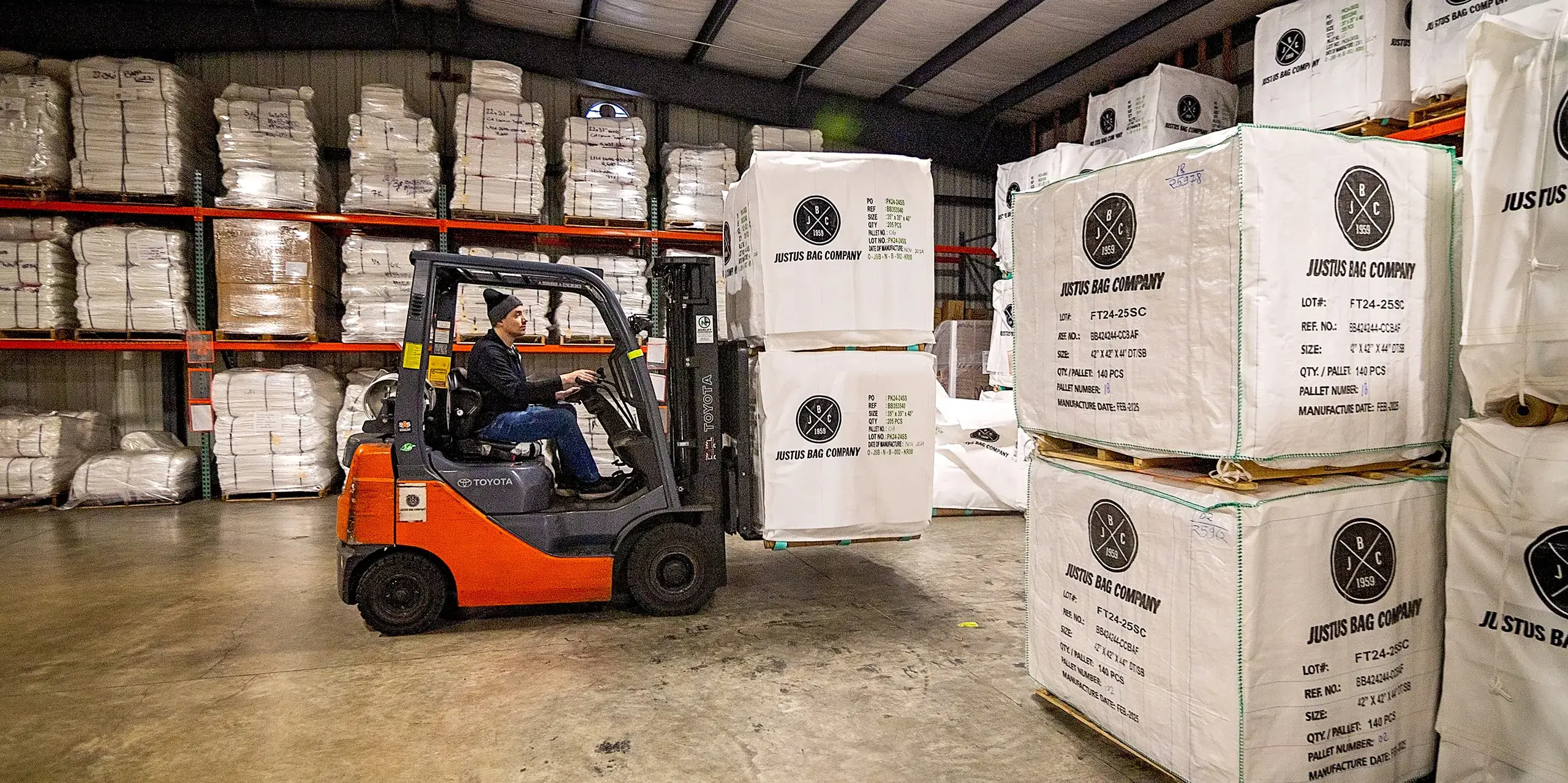 A man moving pallets of custom bags with a forklift